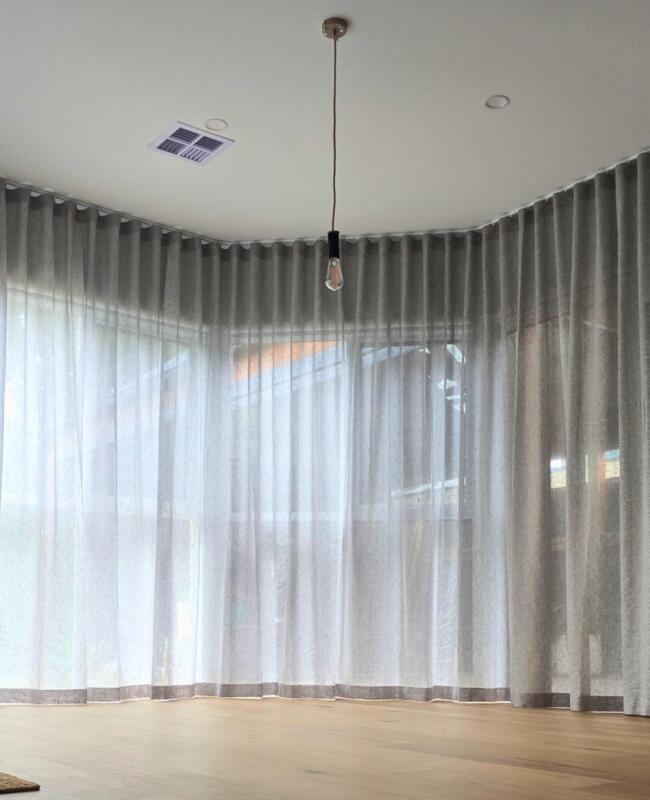 Dining space with sheer curtains on custom bent tracks