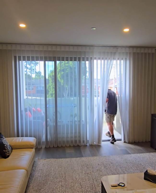Person walking through closed Veri Shades onto balcony