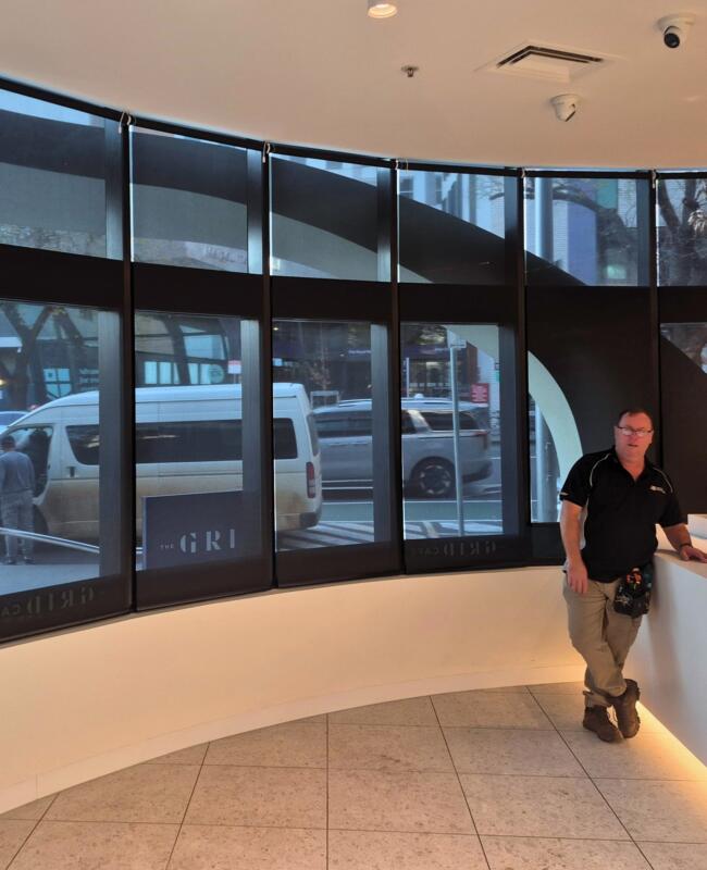 Bay of windows with black screen rollers in a café