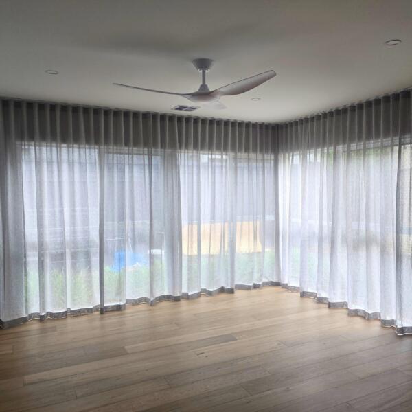 Living space with sheers on a bent track