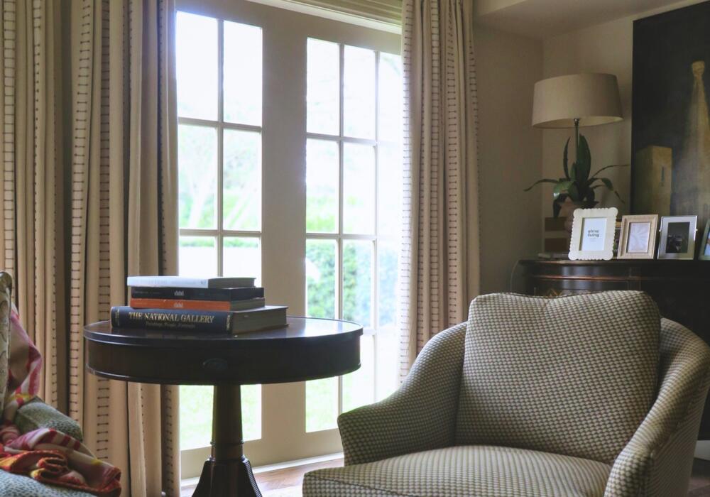 Sitting room with layered textiles, featuring textured pinch-pleat curtains installed by Fabric Creations