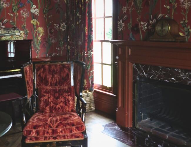 Rich, red study with wallpaper to match drapes installed by Fabric Creations